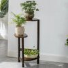 repose plante vintage marron avec pots de fleurs dessus dans un salon